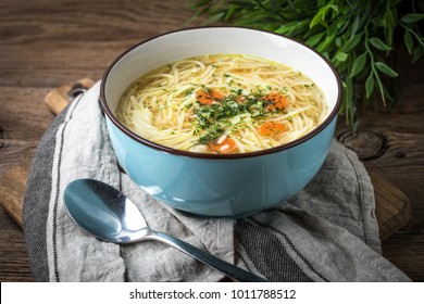 Broth - Chicken Soup With Noodles In A Blue Bowl.