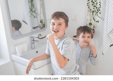 Brother morning fun male kids cleaning teeth toothbrush in front of mirror sink at bathroom with positive emotion. Happy boy children in pajamas toothpaste mouth hygiene healthcare healthy lifestyle - Powered by Shutterstock