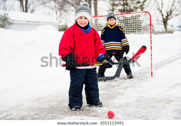 brother playing hockey in\
street