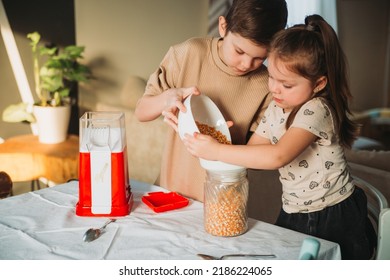 Brother And Sister Cook Popcorn At Home In A Popcorn Maker. Girl Is Waiting For Popcorn To Start Flying Out Of The Popcorn Machine