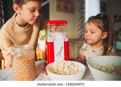 Brother And Sister Cook Popcorn At Home In A Popcorn Maker. Girl Is Waiting For Popcorn To Start Flying Out Of The Popcorn Machine