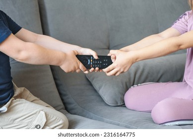 Brother and sister fighting over the TV remote control - Powered by Shutterstock