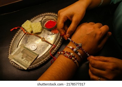 Brother sister love bond sister tying rakhi on brother's hand with shagun and rakhi thali Indian festival - Shutterstock ID 2178577317