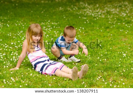 Similar – A boy and a girl in toddlerhood are standing on a log in summer clothes