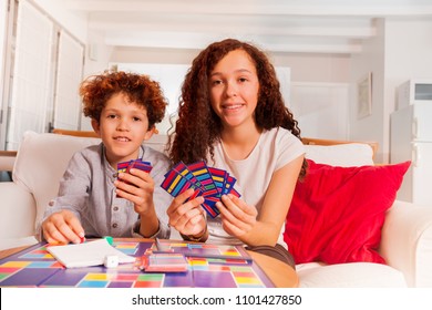 Brother and sister playing card games indoors