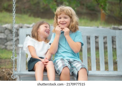 Brother And Sister Playing Outside. Little Boy And Girl Working In The Garden. Two Happy Smiling Laughing Children Swinging On Swing In Summer Park. Kids Summer Holiday Vacation Concept.