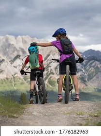 A Brother And Sister Prepare To Descend Down A Hill While On A Family Mountain Bike Ride In Kananaskis Alberta Canada.