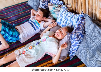 Brother And Sister Relaxing At Beach Cabana