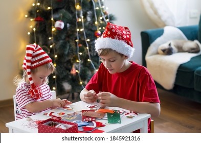 Brother And Sister In Santa Hat Making Decorations For Christmas . Concept Of Winter Kids Creativity And Christmas Craft. Christmas Home Time