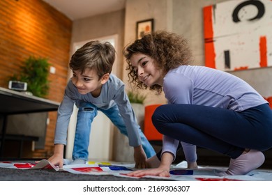 Brother And Sister Siblings Small Caucasian Boy And Girl Child Play Twister Game On The Floor At Home Alone Real People Family Growing Up Leisure Concept Copy Space