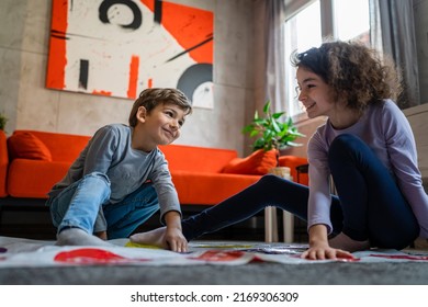 Brother And Sister Siblings Small Caucasian Boy And Girl Child Play Twister Game On The Floor At Home Alone Real People Family Growing Up Leisure Concept Copy Space