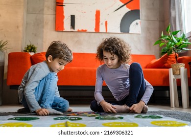 Brother And Sister Siblings Small Caucasian Boy And Girl Child Play Twister Game On The Floor At Home Alone Real People Family Growing Up Leisure Concept Copy Space