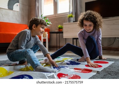 Brother And Sister Siblings Small Caucasian Boy And Girl Child Play Twister Game On The Floor At Home Alone Real People Family Growing Up Leisure Concept Copy Space