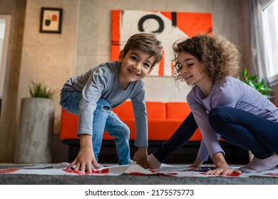 Brother And Sister Siblings Small Caucasian Boy And Girl Child Play Twister Game On The Floor At Home Alone Real People Family Growing Up Leisure Concept Copy Space