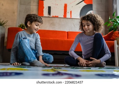 Brother And Sister Siblings Small Caucasian Boy And Girl Child Play Twister Game On The Floor At Home Alone Real People Family Growing Up Leisure Concept Copy Space