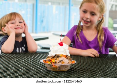 Brother And Sister Siblings Staring At Giant Ice Cream Sundae