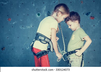 brother and sister standing near a rock wall for climbing indoor - Powered by Shutterstock