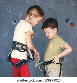 Brother And Sister Standing Near A Rock Wall For Climbing Indoor