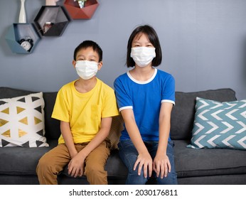brother and sister wears a medical protective mask in a children's room.