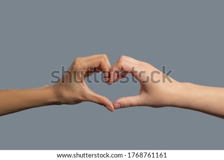 Brotherhood of mankind. Close-up of light-skinned and dark-skinned hands shaping in heart