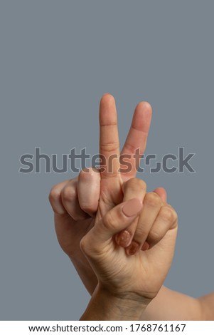 Brotherhood of mankind. Close-up of light-skinned and dark-skinned hands showing peace gesture