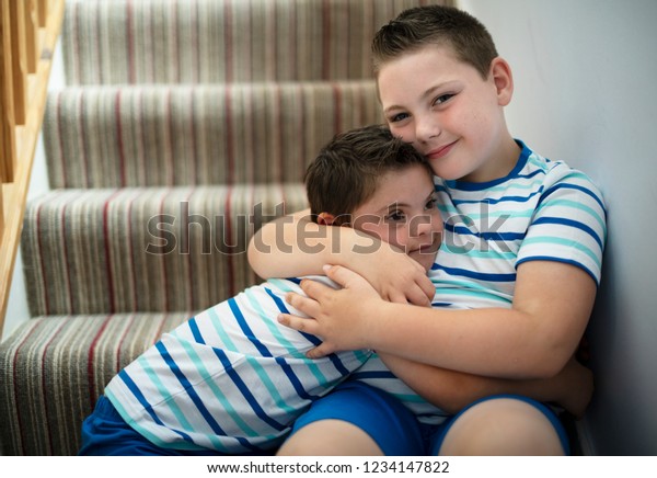 Brothers hugging at the\
stairs