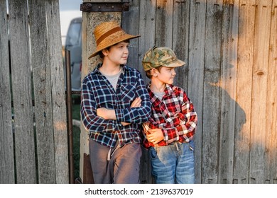 The brothers are standing near the fence of a village house.
