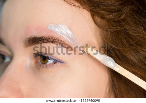 Brow master applying hot wax for brows epilation,\
lamination and waxing. Professional care for face and brow beauty\
procedures. 