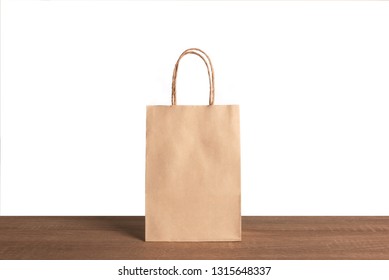 Brow Paper Bag On Wood Table Over White Background.