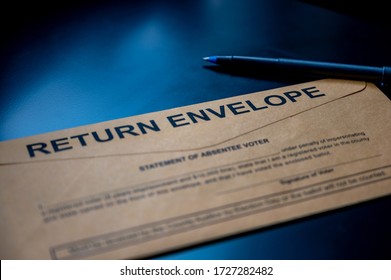 Brown Absentee Ballot Return Envelope On A Black Desk With Ink Pen