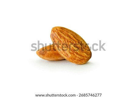 Brown almond nuts in stack are isolated on white background with clipping path.