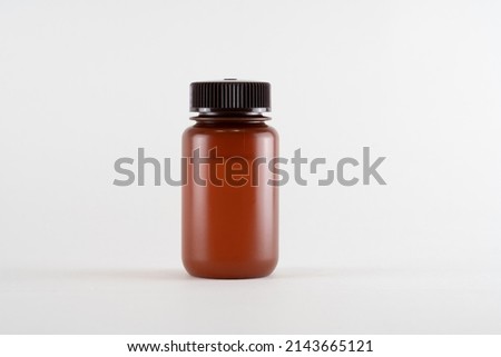 Brown amber medicine glass bottle of essential oil isolated on white background
