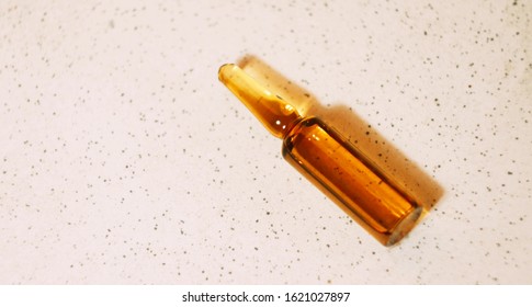 Brown Ampoule With Medicine On Light Background. Illness Treatment Concept. Pharmaceutical Business. Skincare Products