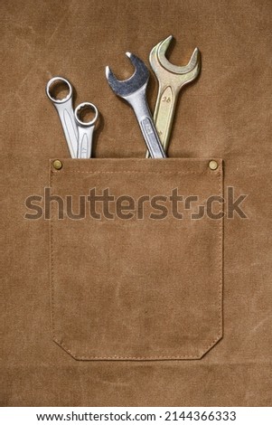 Brown apron pocket with construction tools. Concepts of Labor Day. Selective focus	