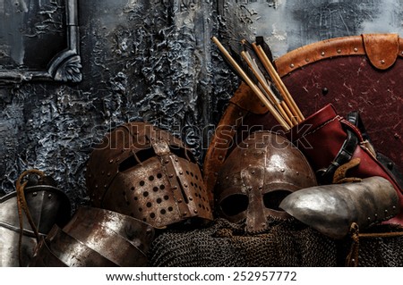 Brown armours. Two helmets, arrows, shield and armours on grey background.