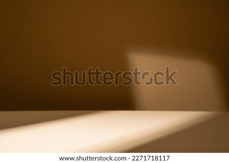 Brown background for product display with shadows and natural sun light in the middle.