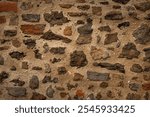 brown background from restored ancient medieval weathered wall made of stones and beige cement. creative element of european architecture