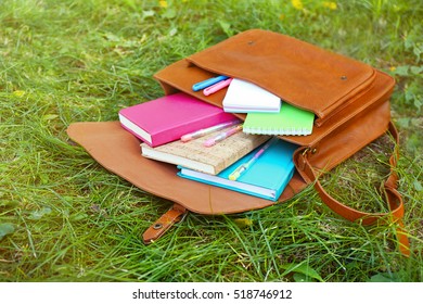 Brown Bag With School Accessories On Green Grass