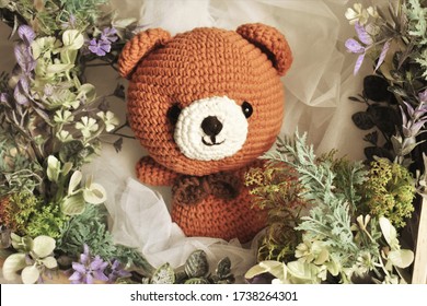Brown bear. Cute crocheting. Bear crochet. Vintage theme. Woolen. Green flame. Forest theme. Knitting background. Pastel vintage.  Home decoration. Woolen animal. Handmade. Leaves. Animal toy for kids