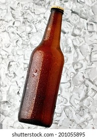 Brown beer bottle with drops on ice, top view