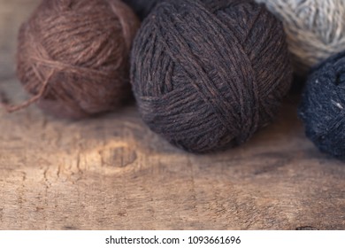 Brown and beige yarn balls on a rustic wooden background, toned, wabi sabi style