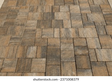 Brown and black interlocking paver blocks of different shapes. Stone effect for outdoor pavement.  Background and texture