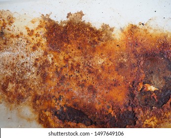 Brown, black and yellow rust and dirt on white enamel. Rusted brown and white abstract texture. Corroded white metal background. Rusty metal surface with streaks of rust. Rusty corrosion. 