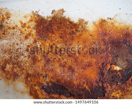 Brown, black and yellow rust and dirt on white enamel. Rusted brown and white abstract texture. Corroded white metal background. Rusty metal surface with streaks of rust. Rusty corrosion. 