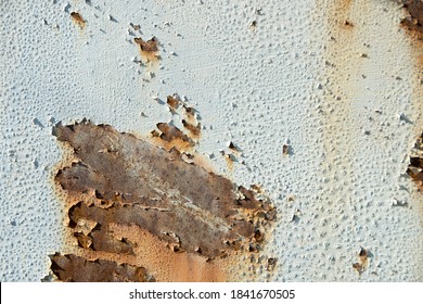 Brown, black and yellow rust on white enamel. Rusted brown and white abstract texture. Corroded white metal background. Rusted white painted metal wall. Rusty metal surface with streaks of rust. 