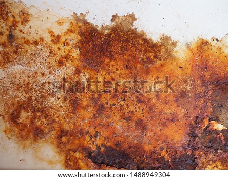 Brown, black and yellow rust on white enamel. Rusted brown and white abstract texture. Corroded white metal background. Rusted white painted metal wall. Rusty metal surface with streaks of rust. 