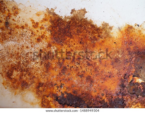 Brown, black and yellow rust on white enamel. Rusted\
brown and white abstract texture. Corroded white metal background.\
Rusted white painted metal wall. Rusty metal surface with streaks\
of rust. 