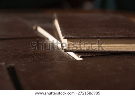 Brown book closed on a stack of books as a base