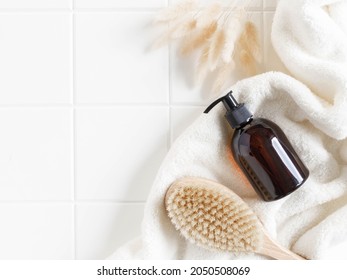 Brown Bottle Mockup For Bathing Products In Bathroom, Spa Shampoo, Shower Gel, Liquid Soap On Cotton Towel And Wood Brush Flat Lay. Top View. Copy Space