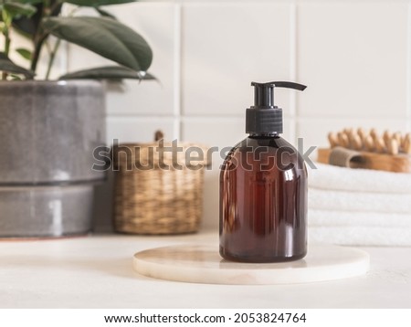 Brown bottle mockup for bathing products in bathroom, spa shampoo, shower gel, liquid soap on marble podium and various accessories front view.